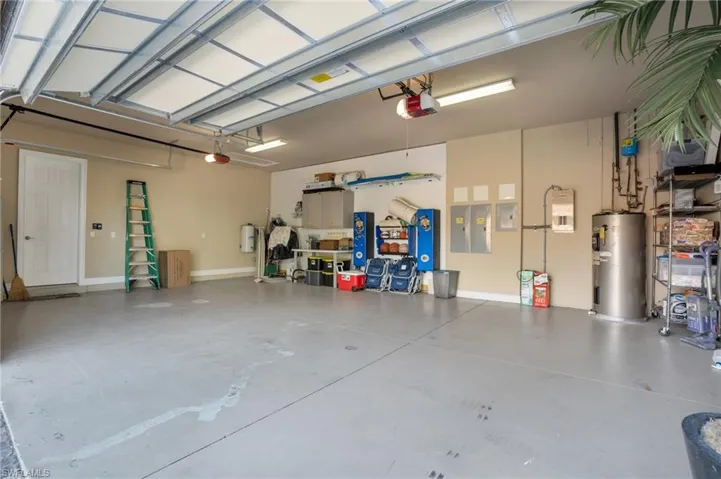 Garage featuring water heater and electric panel