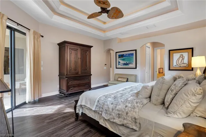 Bedroom with access to outside, wood finished floors, a ceiling fan, and ornamental molding