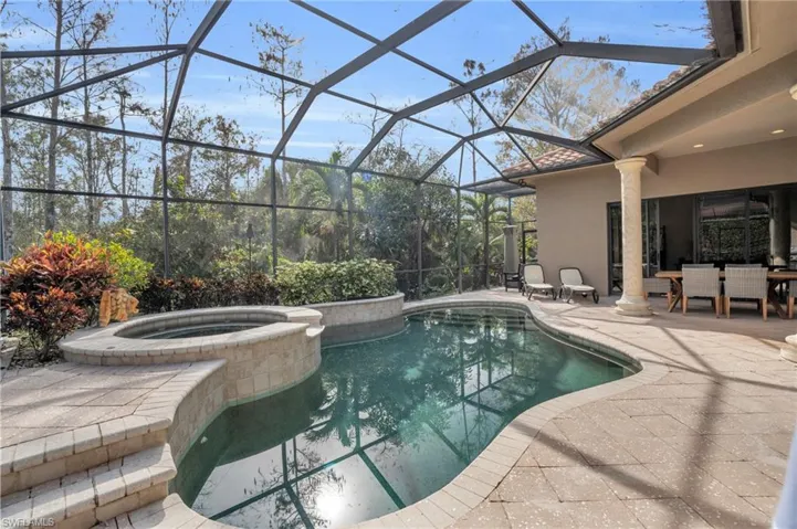 Combined pool / hot tub featuring a patio, outdoor dining area, a sunroom, and a lanai