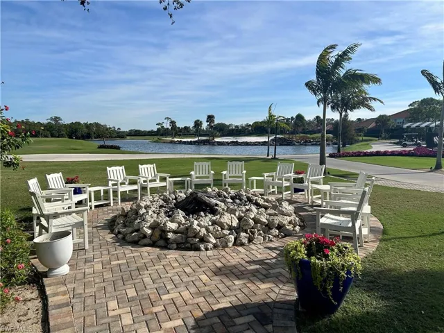 View of patio featuring a fire pit, a water view, and view of golf course