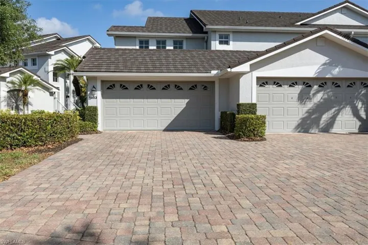 View of front of property with stucco siding, an attached garage, and decorative driveway
