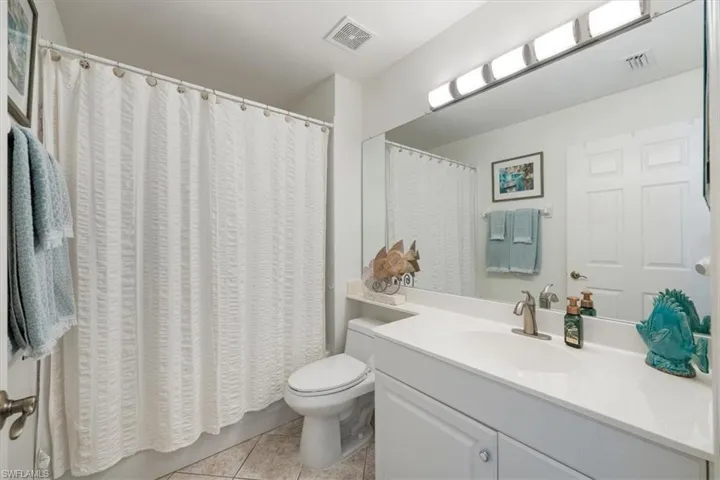 Bathroom with vanity, tile patterned flooring, toilet, and visible vents