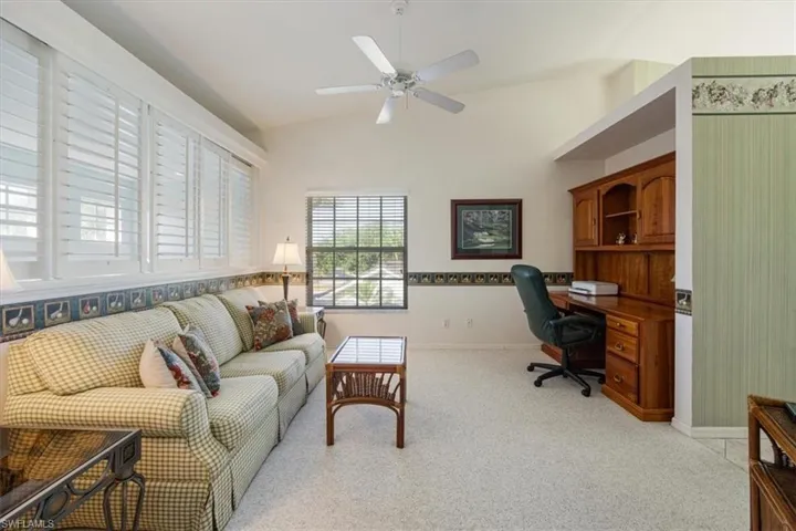 Office featuring light colored carpet, ceiling fan, vaulted ceiling, and baseboards
