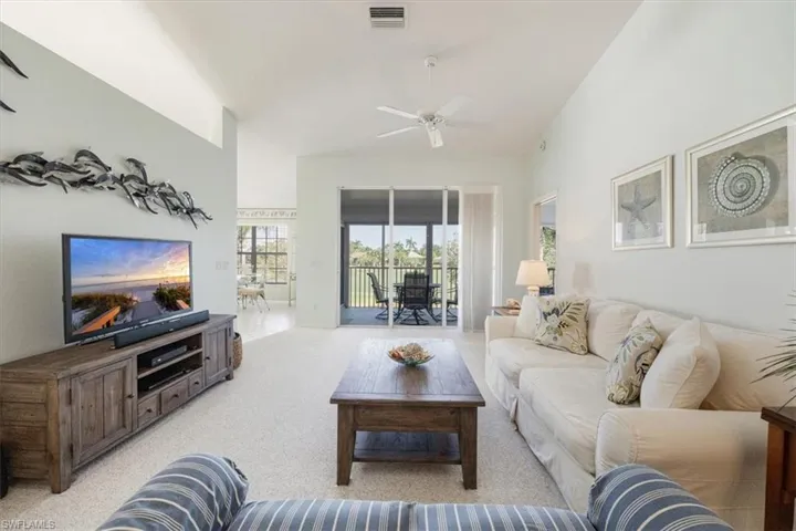 Living room featuring a ceiling fan, light colored carpet, and visible vents