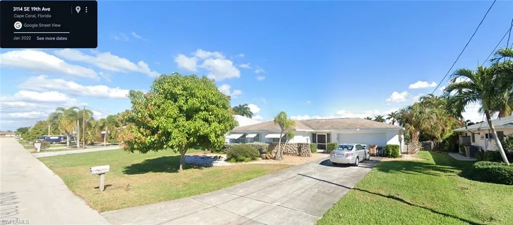 View of front of property with a front yard, a garage, and cooling unit