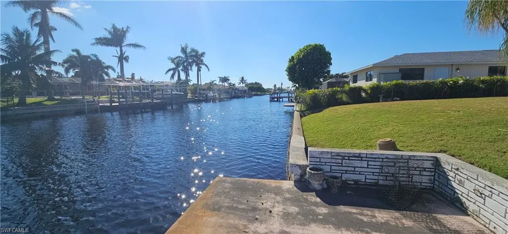 Dock area featuring a lawn and a water view