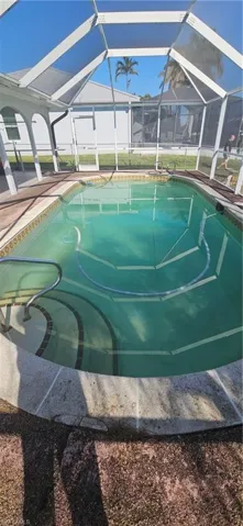 View of swimming pool featuring glass enclosure