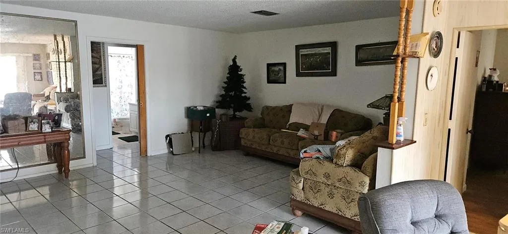 Living room featuring light tile patterned floors and a textured ceiling