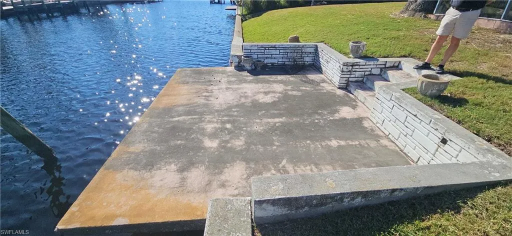 View of dock featuring a water view and a lawn