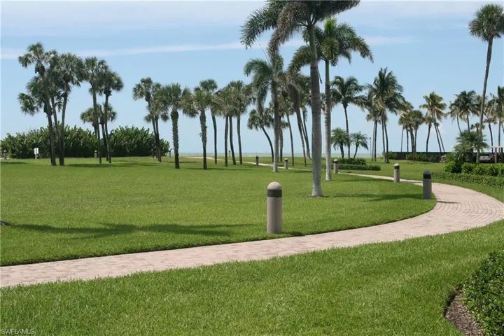 Walk way to beach with large grassy lawn in middle
