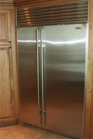 Detailed view of built in refrigerator and brown cabinets