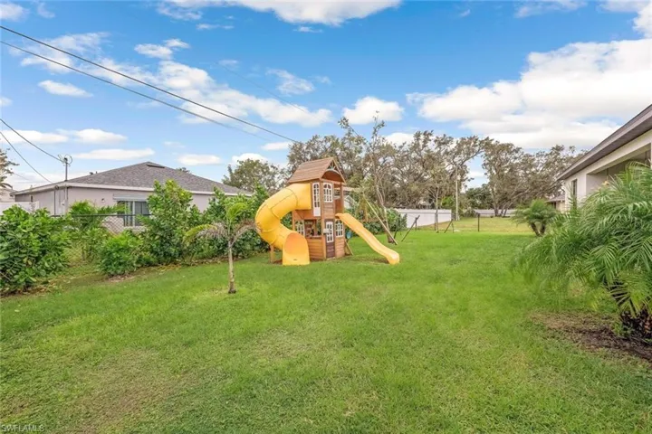 View of yard featuring fence and a playground