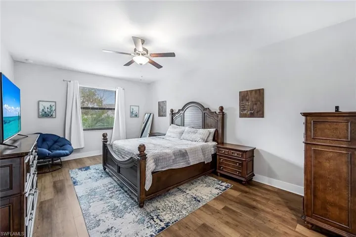 Bedroom featuring baseboards, dark wood finished floors, and ceiling fan