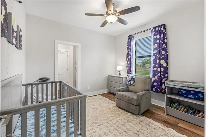 #3 Bedroom featuring baseboards, ceiling fan, a nursery area, and wood finished floors