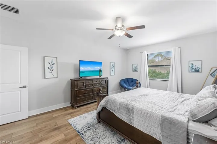 Bedroom featuring baseboards, visible vents, ceiling fan, and light wood-type flooring
