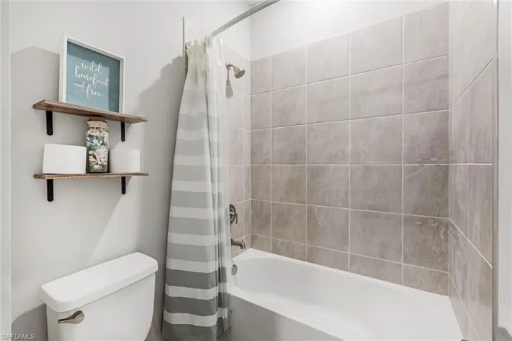#3 Full bath featuring toilet and shower / bath combination with curtain