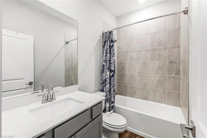 #2 Bathroom featuring vanity, toilet, shower / bath combo with shower curtain, recessed lighting, and wood finished floors