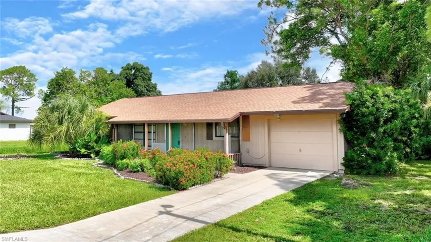 Ranch-style home featuring a garage and a front yard