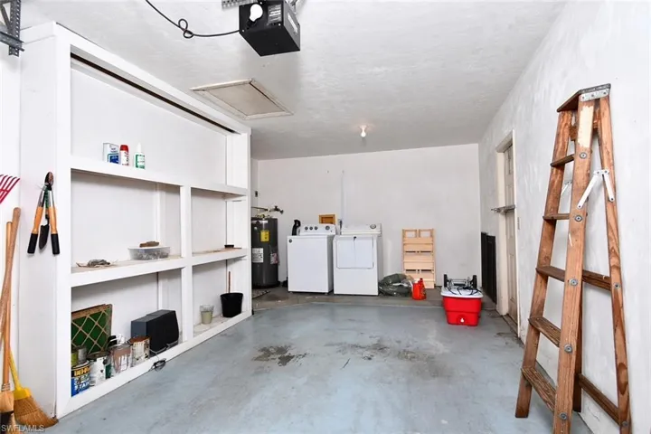 Garage with electric water heater, a garage door opener, and washing machine and clothes dryer