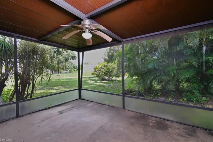 Unfurnished sunroom featuring lofted ceiling, wood ceiling, and ceiling fan