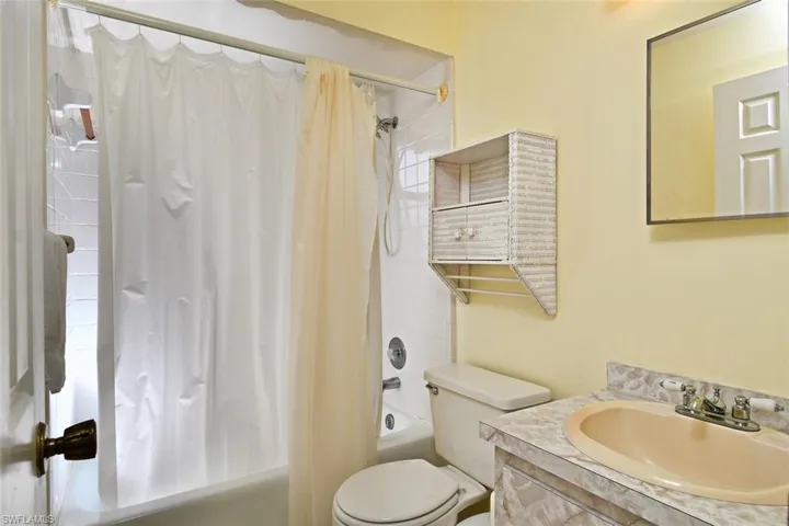 Full bathroom featuring vanity, toilet, and shower / tub combo with curtain