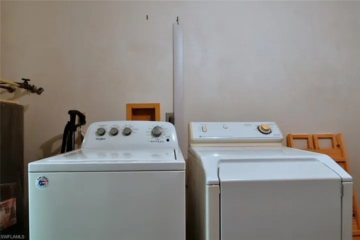 Washroom featuring water heater and independent washer and dryer
