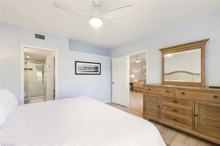 Bedroom featuring a ceiling fan, light wood-type flooring, and ensuite bathroom