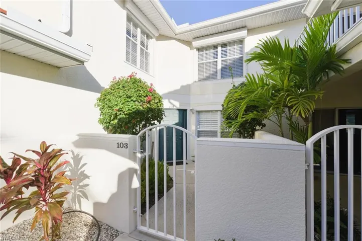 Doorway to property featuring a gate and stucco siding