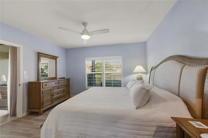 Bedroom with multiple windows, wood finished floors, and ceiling fan