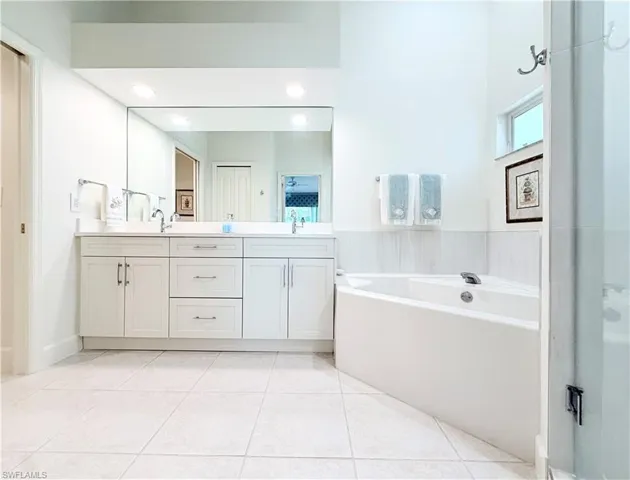 Updated primary bath has separate walk in shower and garden tub, 2 sink vanity, linen closet and separate water closet for privacy