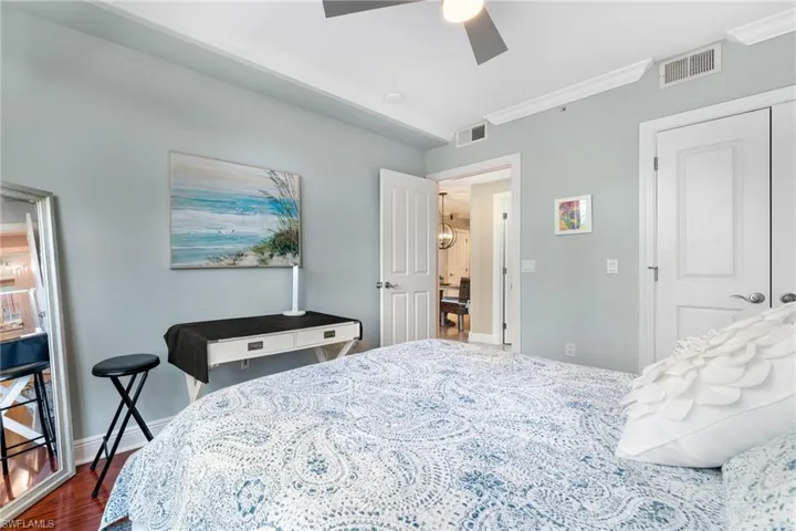 Bedroom featuring a closet, dark wood-type flooring, ceiling fan, and ornamental molding