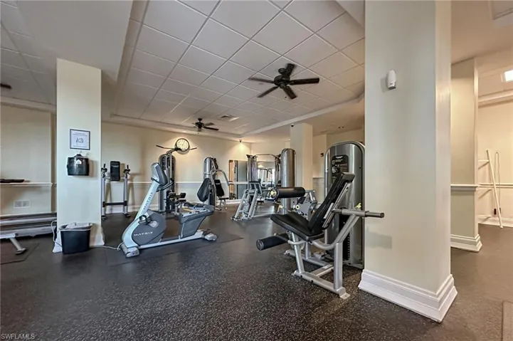 Gym with a paneled ceiling and ceiling fan