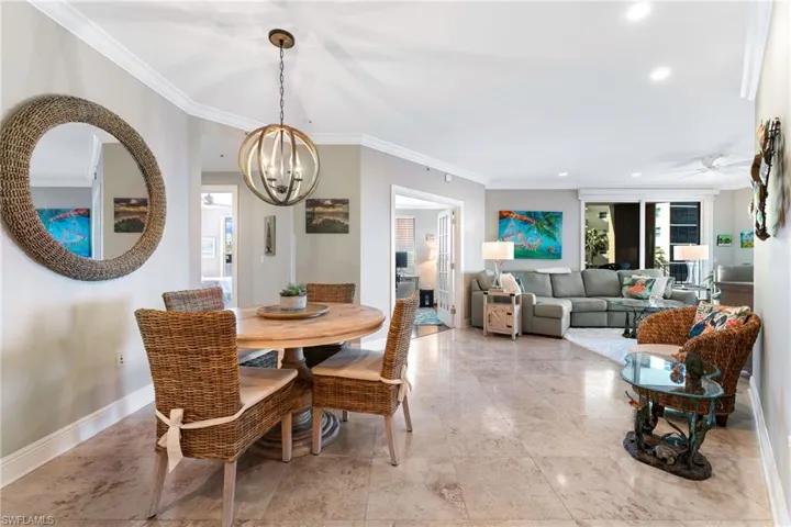 Dining space featuring ceiling fan with notable chandelier and ornamental molding