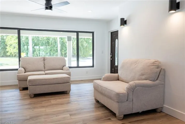 Living room with recessed lighting, light wood finished floors, a ceiling fan, and baseboards