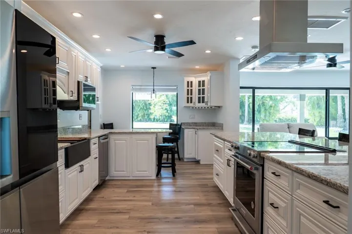 Kitchen featuring island exhaust hood, recessed lighting, appliances with stainless steel finishes, and plenty of natural light