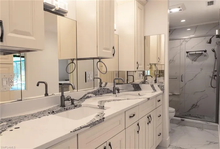 Bathroom featuring a sink, a marble finish shower, marble finish floor, toilet, and recessed lighting
