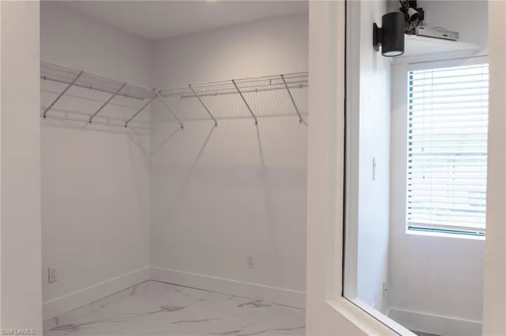 Walk in closet with marble finish floor