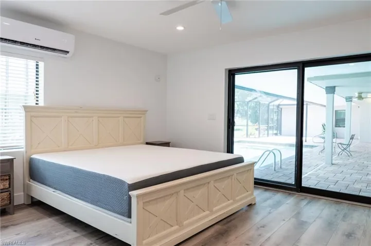 Bedroom with recessed lighting, a wall mounted air conditioner, light wood-style floors, access to outside, and ceiling fan