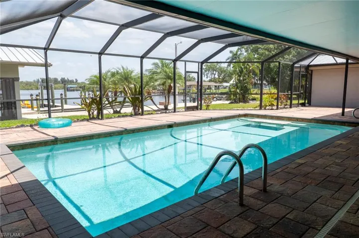 Pool featuring a patio area, a lanai, and a water view