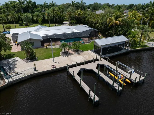 Dock area with a yard, boat lift, and a water view