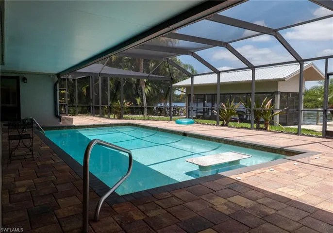 Pool with a patio area and glass enclosure