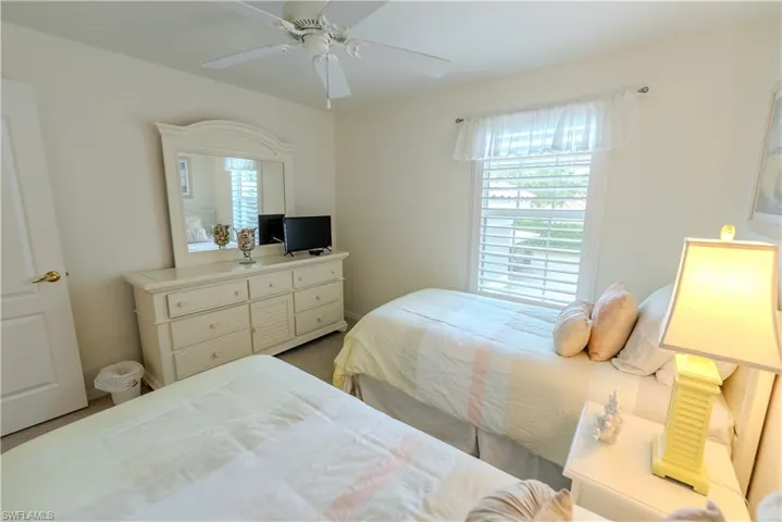 Carpeted bedroom featuring ceiling fan