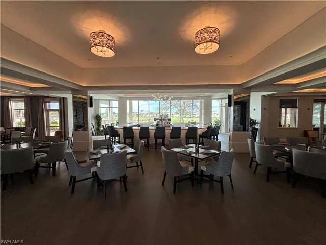 Dining space featuring a tray ceiling, wood-type flooring, and an inviting chandelier