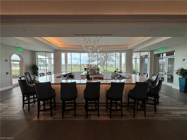 Dining room with an inviting chandelier, plenty of natural light, and a raised ceiling