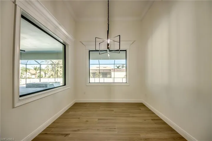 Unfurnished dining area featuring ornamental molding, a chandelier, and light hardwood / wood-style flooring