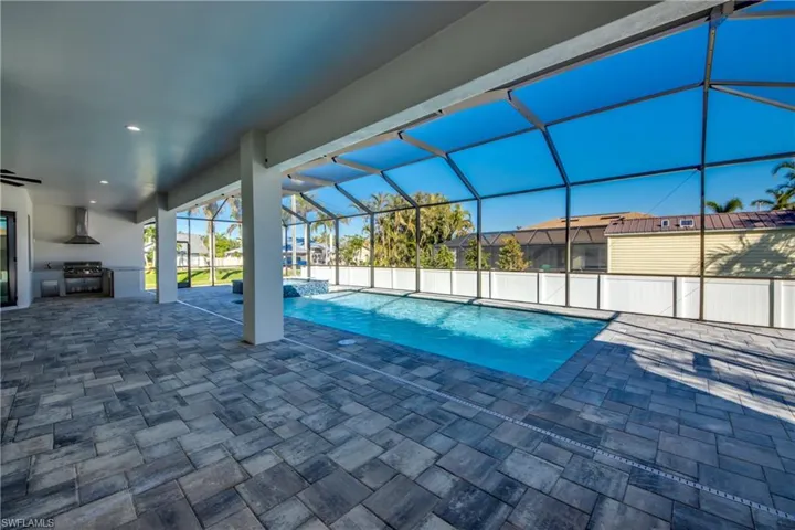 View of swimming pool featuring area for grilling, grilling area, a patio, and a lanai