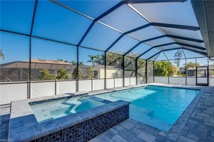 View of swimming pool with an in ground hot tub, a lanai, and a patio area