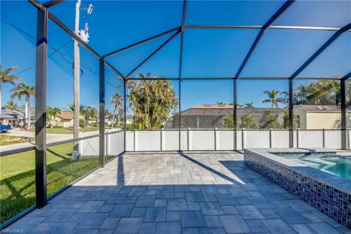 View of patio / terrace with a lanai and an in ground hot tub