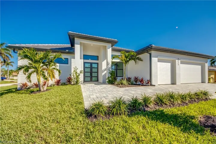 View of front facade featuring a front lawn and a garage