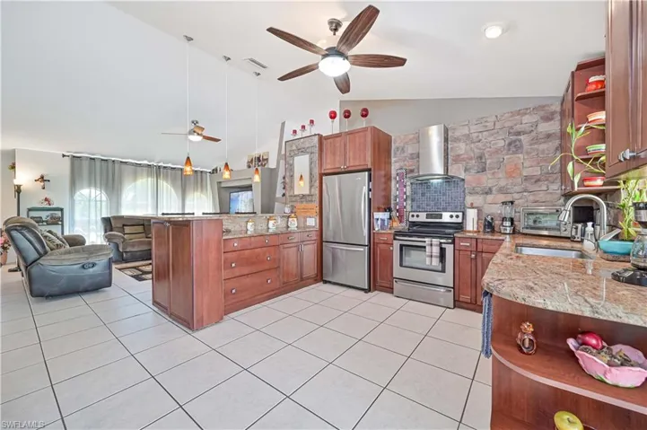 Kitchen featuring stainless steel appliances, open shelves, range hood, a peninsula, and ceiling fan